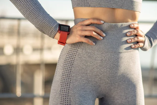 Close up picture of a female in grey sportswear and with a smartwatch on her wrist — Foto de Stock