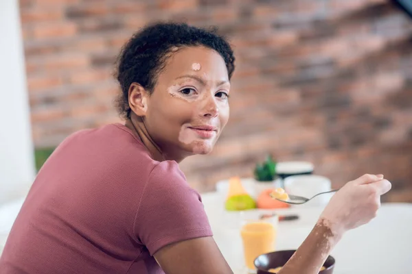 Dark-skinned young woman having breakfast at home — Fotografia de Stock