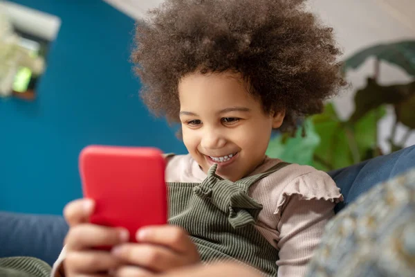 Χαρούμενο χαριτωμένο σκούρο δέρμα κοριτσάκι με smartphone — Φωτογραφία Αρχείου