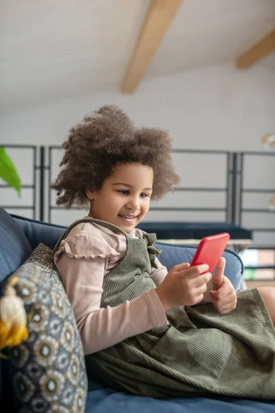 Χαριτωμένο κοριτσάκι με smartphone στο σπίτι — Φωτογραφία Αρχείου