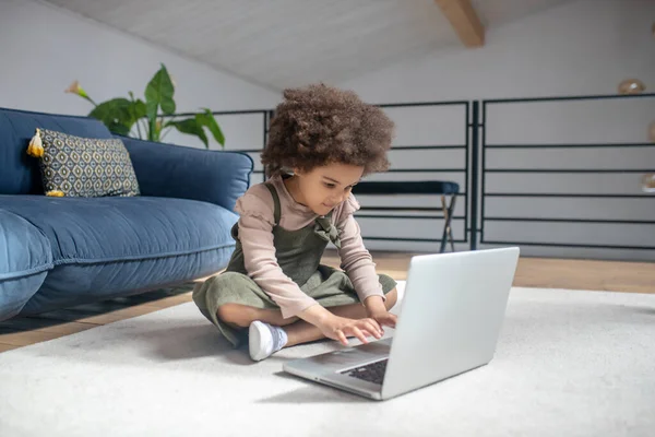 Klein meisje hand in hand over laptop toetsenbord — Stockfoto