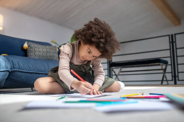 Sério focado pequena menina pintura sentado no chão — Fotografia de Stock