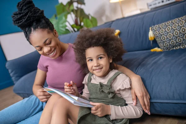 Vreugdevolle donkere huid moeder en dochter schilderen thuis — Stockfoto