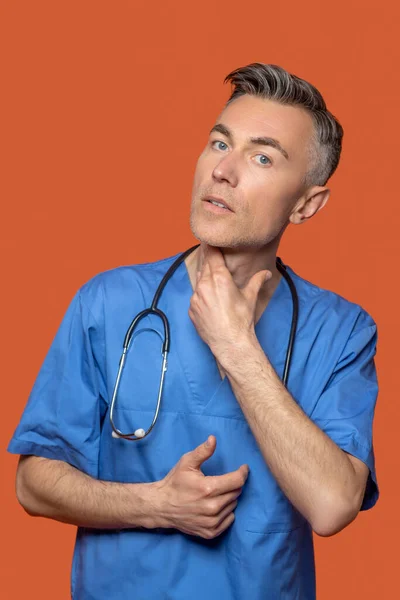 Médico masculino atento tocando seu pescoço — Fotografia de Stock