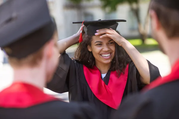 Graduados de universidades sintiéndose felices y sonriendo amablemente — Foto de Stock