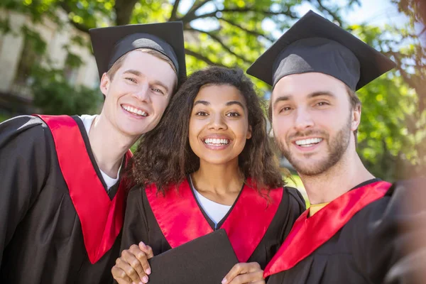 Eine Gruppe von Absolventen verbringt Zeit miteinander und fühlt sich vereint — Stockfoto