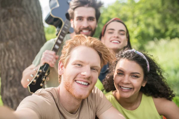 Szczęśliwy chłopaki i dziewczyny biorąc selfie w natura — Zdjęcie stockowe