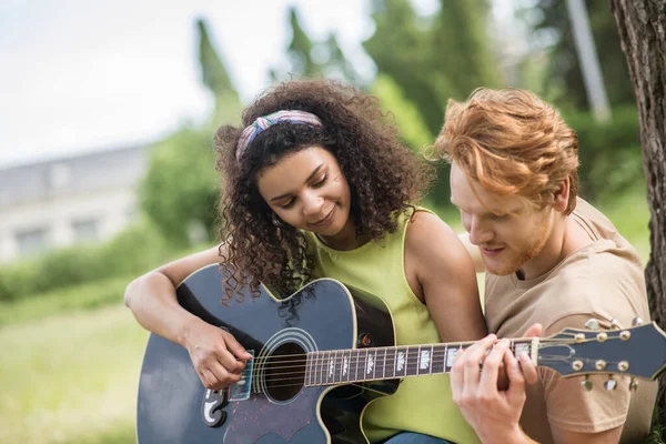 Guy bringt seiner Freundin bei, Gitarre zu spielen — Stockfoto