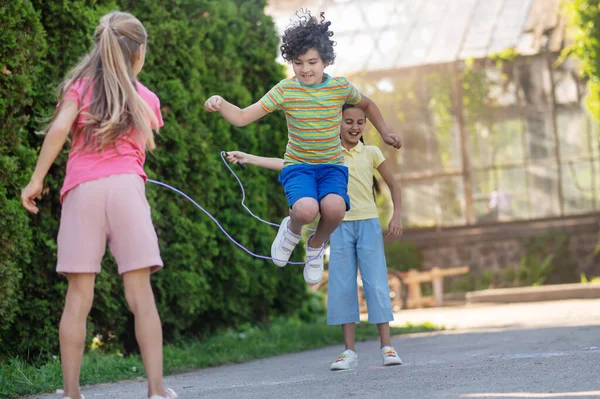 Niño en salto y dos chicas con skippingrope — Foto de Stock