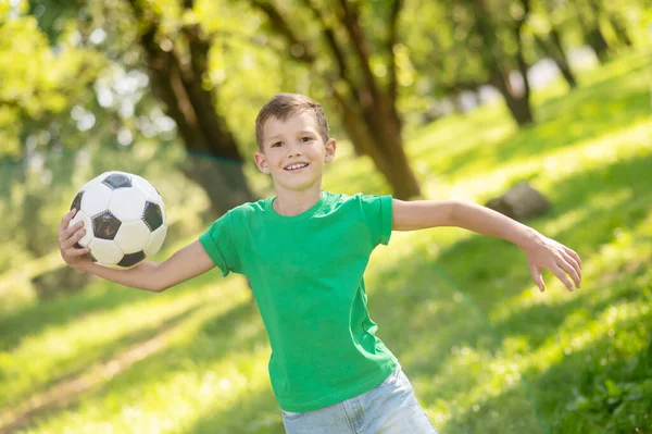 Radostný chlapec běží s míčem v parku — Stock fotografie