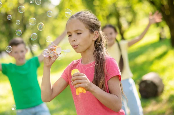 Chica soplando aire y burbujas de jabón volador — Foto de Stock