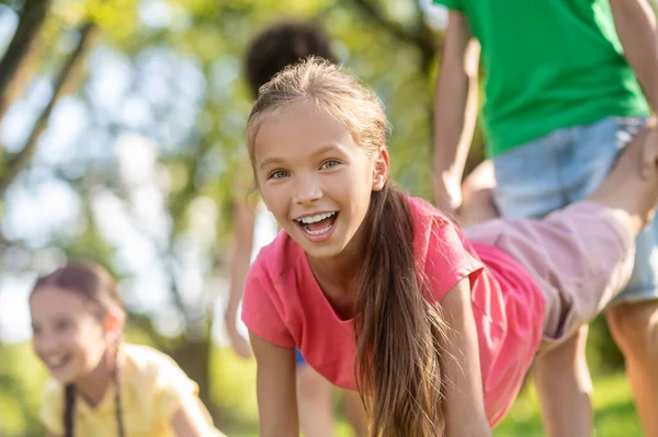 Joyeuses filles et garçons jouant activement dans le parc — Photo