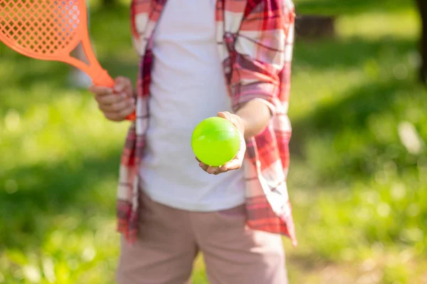 Main d'enfant étirant la balle de tennis — Photo