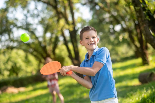 Niño feliz jugando bádminton en la naturaleza —  Fotos de Stock