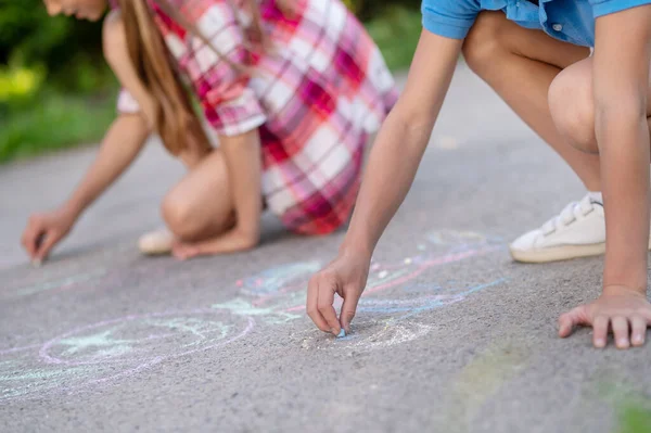 Crianças mãos desenho com lápis de cera no asfalto — Fotografia de Stock