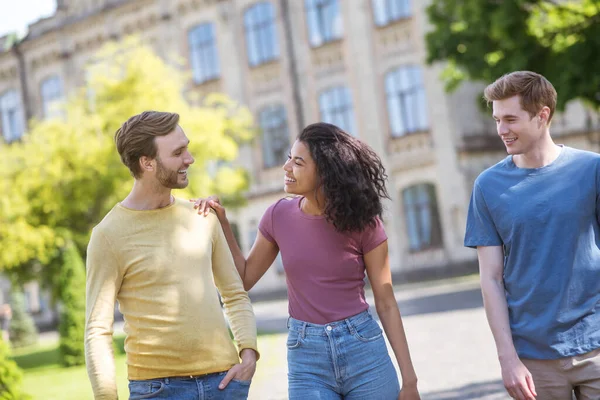 Trois amis passent du temps ensemble et sourient gentiment — Photo