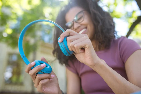 Sorrindo menina sonhadora em fones de ouvido ouvindo música — Fotografia de Stock