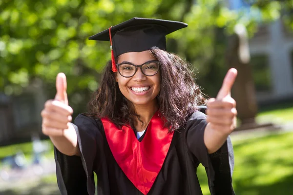 Pretty young girl in academic cap feeling happy about graduation — Stock Photo, Image