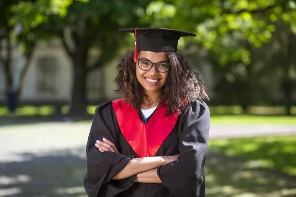 Pretty young girl in academic cap feeling happy about graduation — Stock Photo, Image