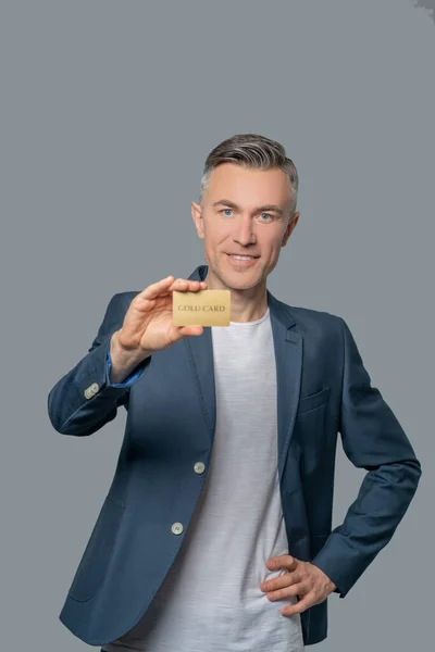 Joyful bem sucedido homem mostrando cartão bancário — Fotografia de Stock