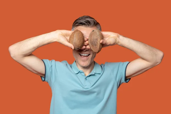 Man som håller två kokosnötter i ögonhöjd — Stockfoto
