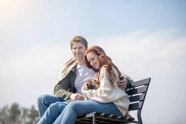 Šťastný muž a žena s kočkou sedí venku — Stock fotografie