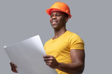 Koruyucu hemlet giymiş koyu tenli bir inşaat mühendisi.