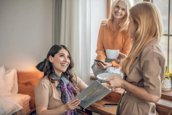 Grupo de mujeres pasando tiempo juntas y mirando a través de la revista de moda — Foto de Stock