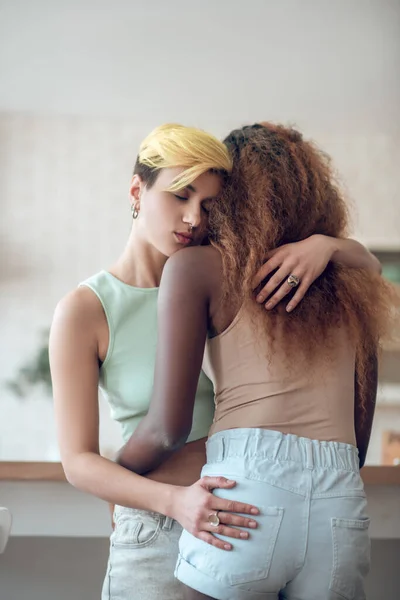 Γυναίκα με κοντά μαλλιά αγκαλιάζει αφροαμερικανή φιλενάδα — Φωτογραφία Αρχείου