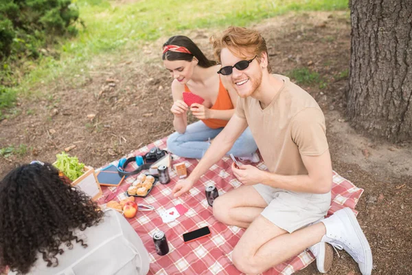 Vista dall'alto degli amici che giocano a carte al picnic — Foto Stock