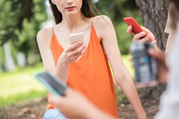 Young people focused on their smartphones in nature — стоковое фото