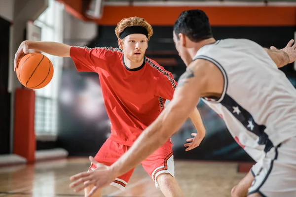 Two young men playing basketball and looking involved — Foto de Stock