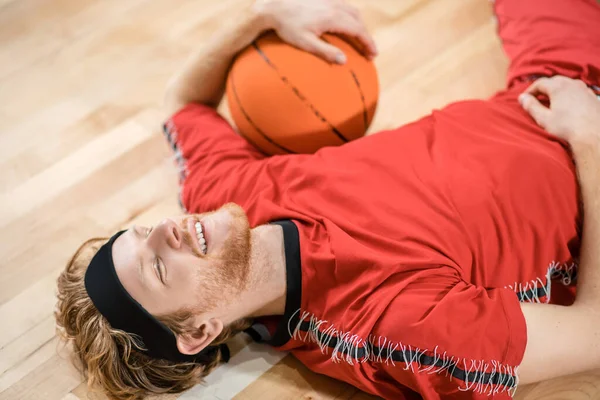 Ginger man in red sportswear resting after the game — Stock Photo, Image