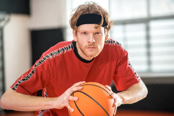 Ginger man in a red sportswear playing basketball — Photo