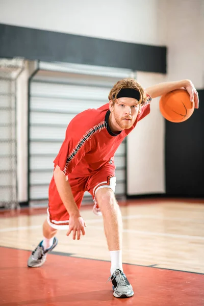 Ginger man in a red sportswear throwing the ball to the basket — Foto de Stock