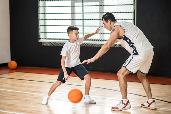 Dark-haired man training a teen in the gym — Foto de Stock