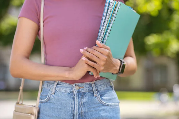 一个穿着粉色T恤手里拿着课本的女孩 — 图库照片
