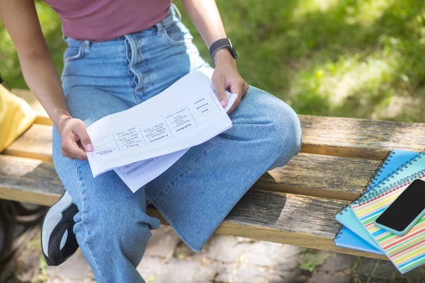 Pembe tişörtlü bir kız parkta bankta oturuyor. — Stok fotoğraf