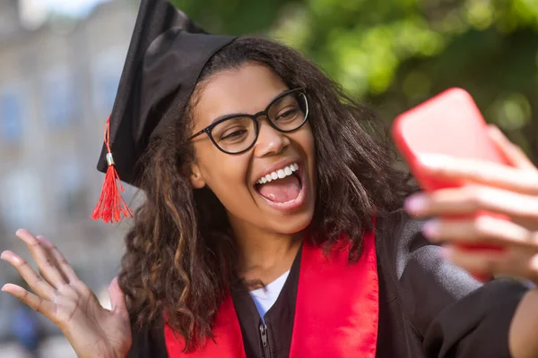 En flicka som har ett videosamtal och dela goda nyheter om examen — Stockfoto