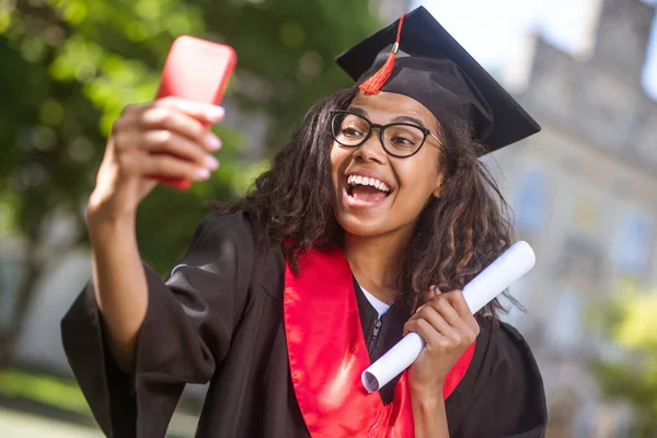 En flicka som har ett videosamtal och dela goda nyheter om examen — Stockfoto