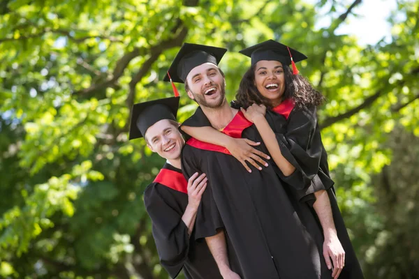 Grupo de graduados de pé no parque e se sentindo incrível — Fotografia de Stock