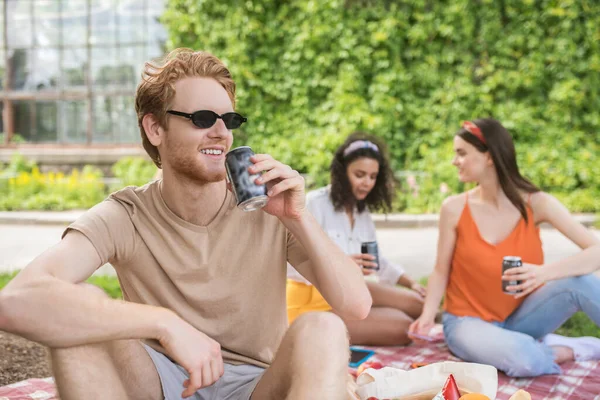 Amical gars dans des lunettes de soleil avec boisson et copines — Photo