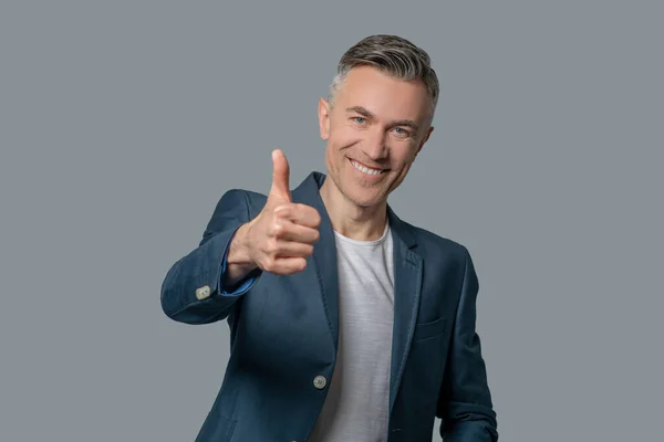 Lächelnder Mann im Sakko zeigt Ok-Geste — Stockfoto