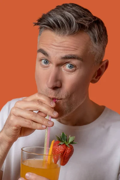 Man drinkt fruitcocktail door stro — Stockfoto