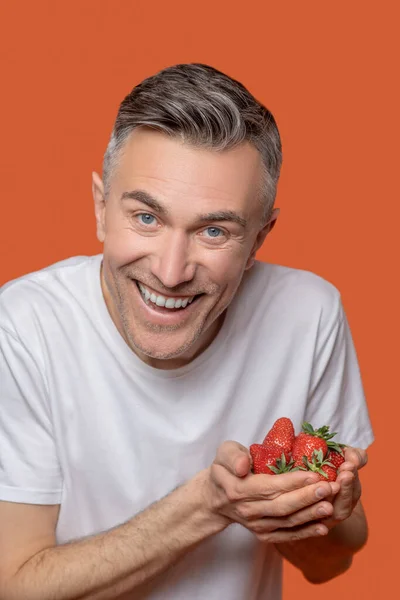 Jubelnder Mann mit reifen Erdbeeren in Händen — Stockfoto