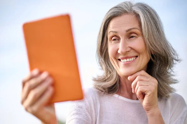 Веселая сияющая женщина перед табличкой на открытом воздухе — стоковое фото