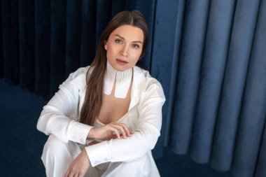 Boynunda bantlarla oturan ve huzurlu görünen güzel bir kadın.