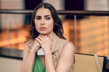 Güzel genç bir kadın bekliyor ve endişeli görünüyor.