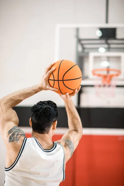 ダークヘアのバスケットボールプレーヤーがリングにボールを投げます — ストック写真
