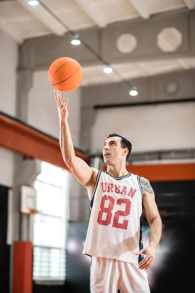 Mörkhårig basketspelare kastar en boll i ringen — Stockfoto